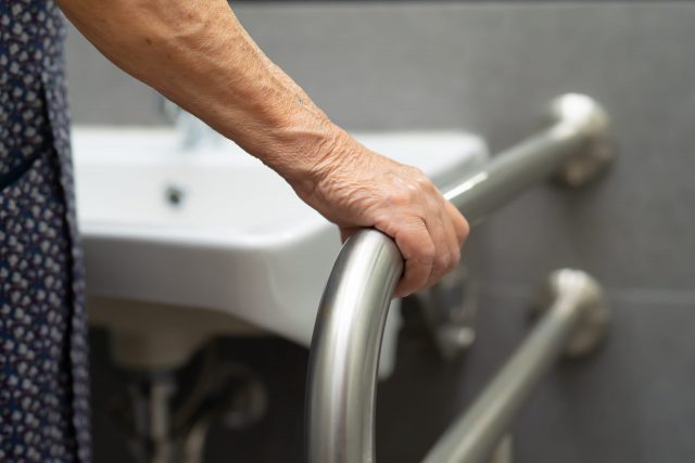 los 18 mejores consejos de seguridad para personas mayores, persona mayor agarrando una barra de seguridad 