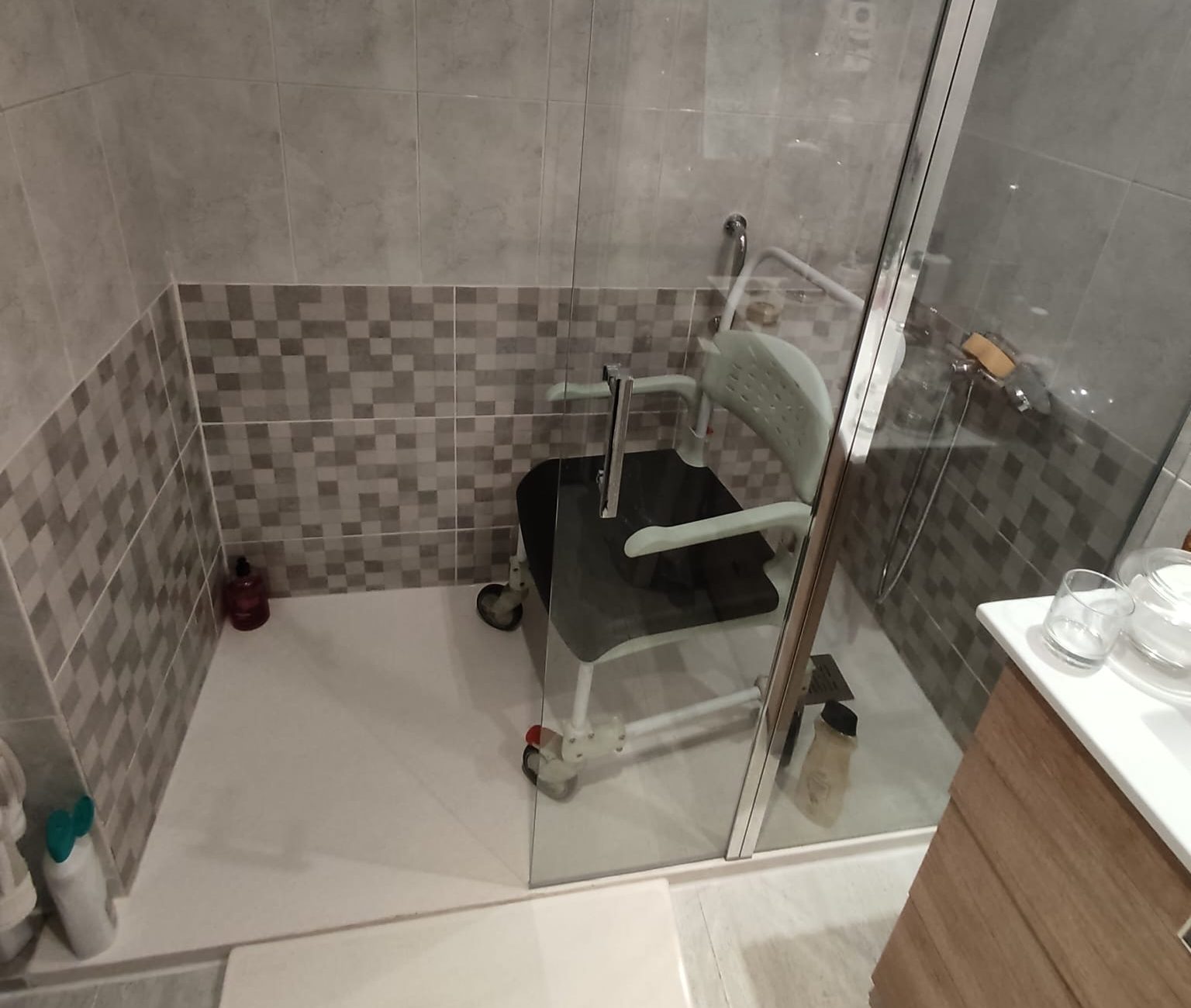 silla para ducha dentro de una zona de ducha adaptada a una persona con movilidad reducida